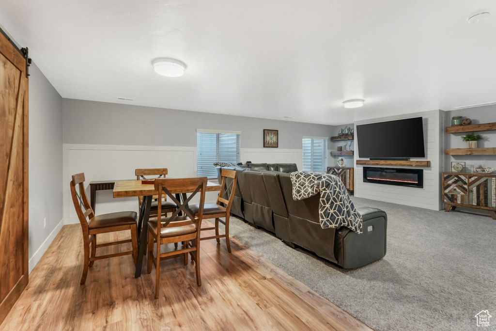 Living area featuring a glass covered fireplace, wood finished floors, and a barn door