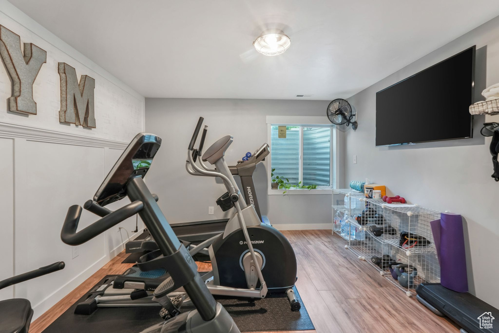 Workout area with wood finished floors and baseboards