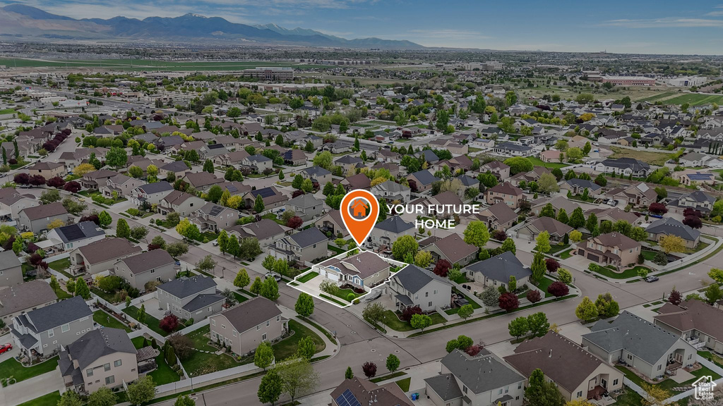 Aerial view of property and surrounding area with mountains and nearby suburban area