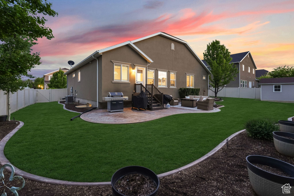 Back of house at dusk with an outdoor hangout area, a patio, and stucco siding