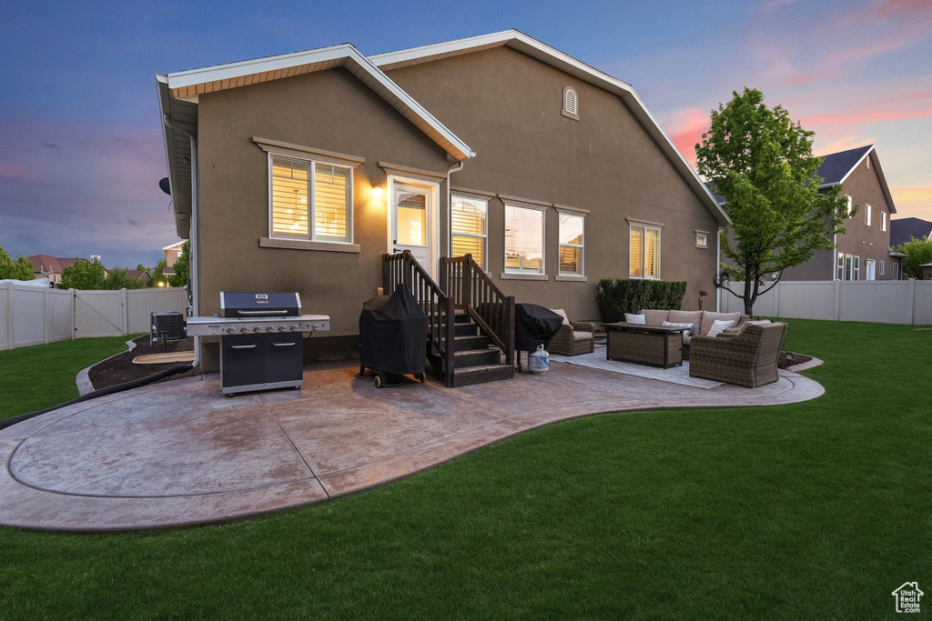 Rear view of house with an outdoor hangout area, a patio area, and stucco siding
