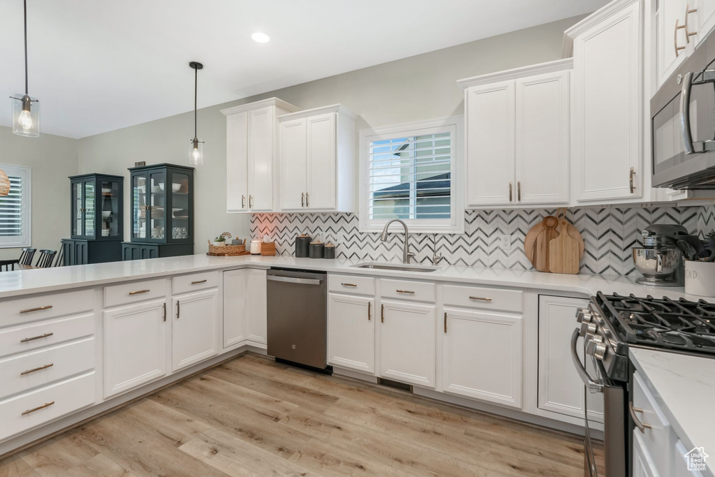 Kitchen featuring a sink, stainless steel dishwasher, gas range oven, tasteful backsplash, and recessed lighting