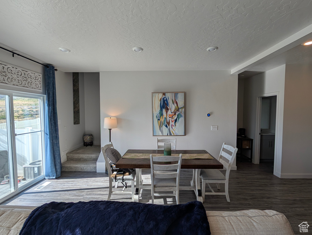 Dining space featuring a textured ceiling, wood finished floors, baseboards, and recessed lighting