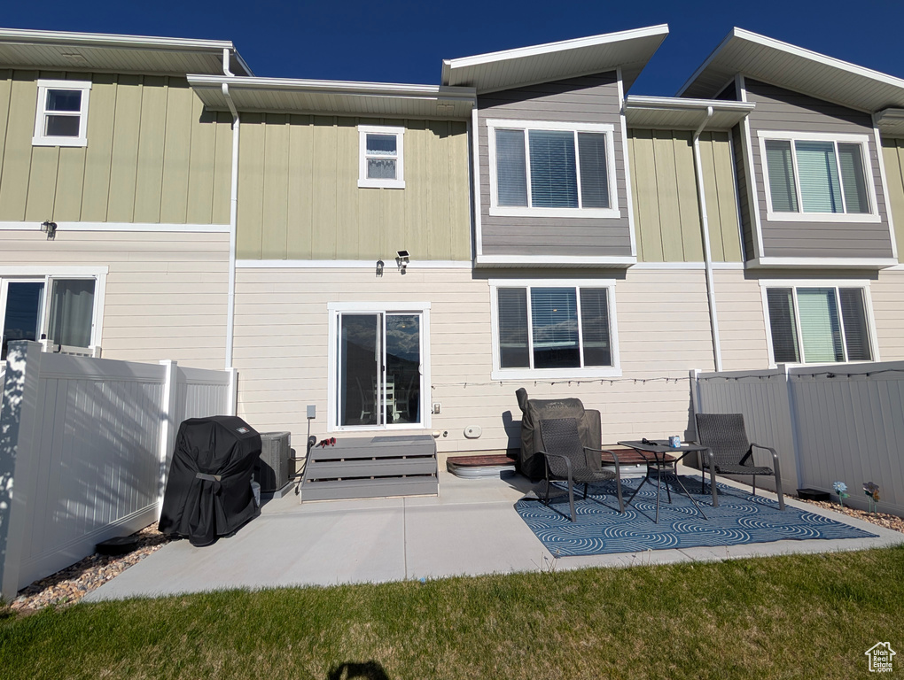 Rear view of property with fence and a patio area