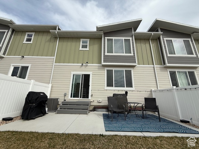 Back of house featuring fence, a patio area, and board and batten siding