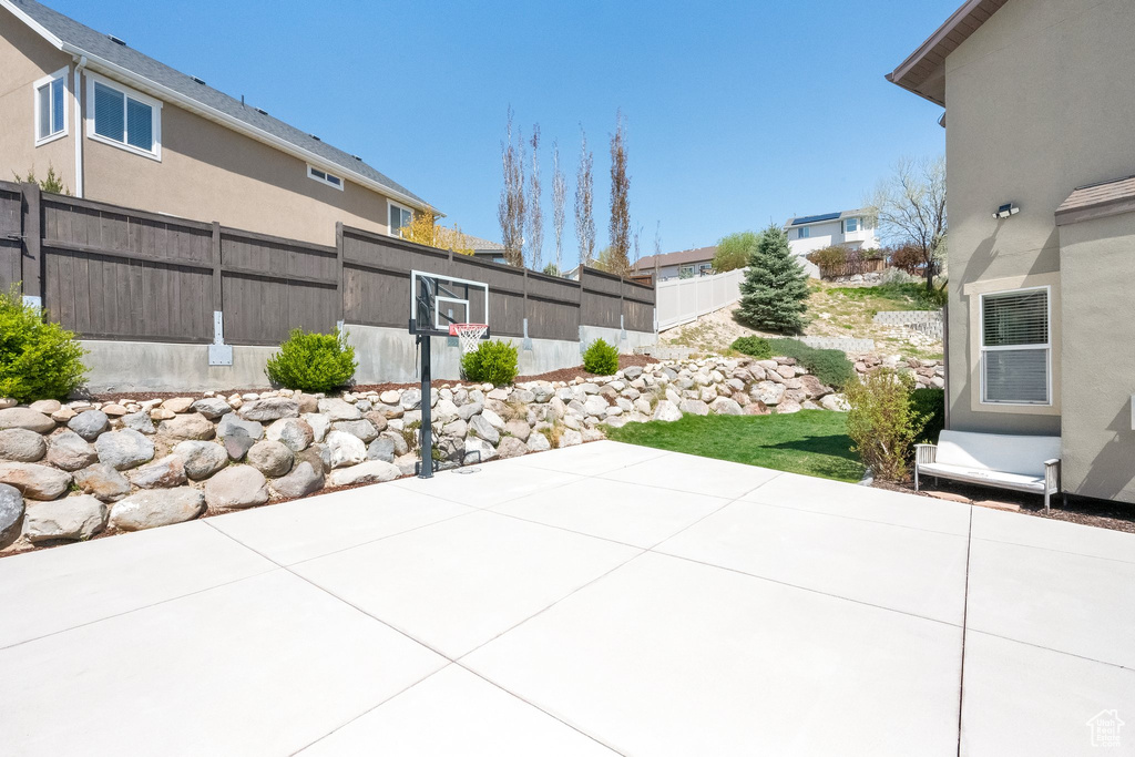 View of patio with fence and basketball hoop
