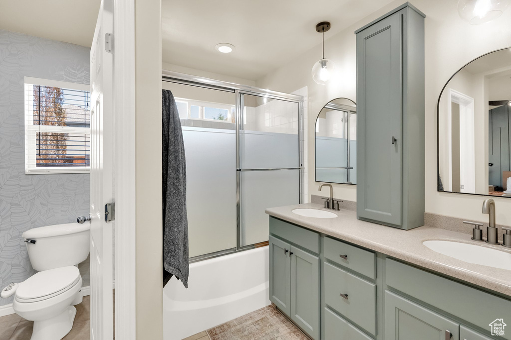 Full bathroom featuring double vanity, toilet, plenty of natural light, and a sink
