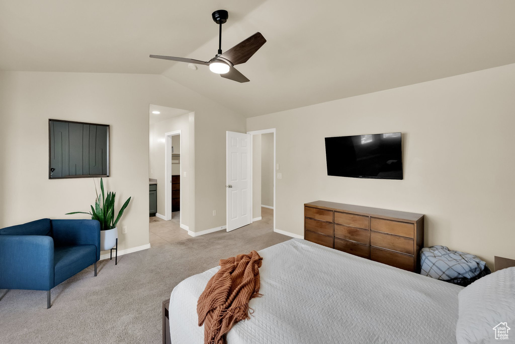 Bedroom featuring lofted ceiling, ensuite bath, baseboards, light colored carpet, and ceiling fan
