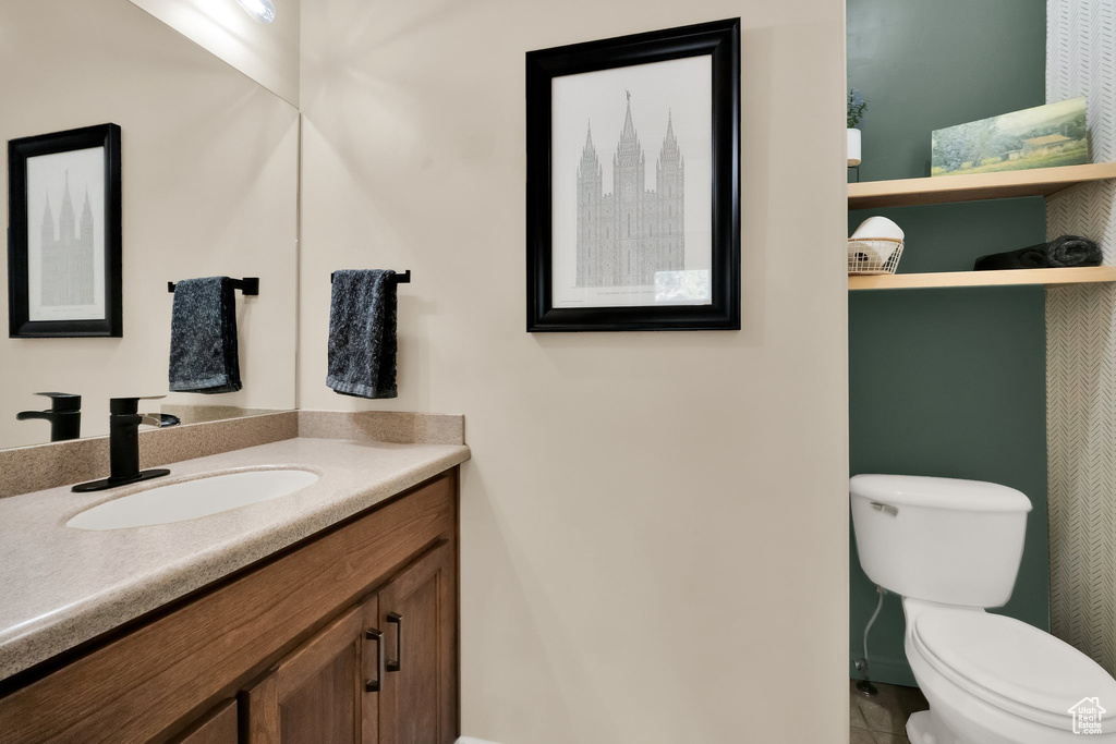 Bathroom featuring toilet, vanity, and tile patterned floors