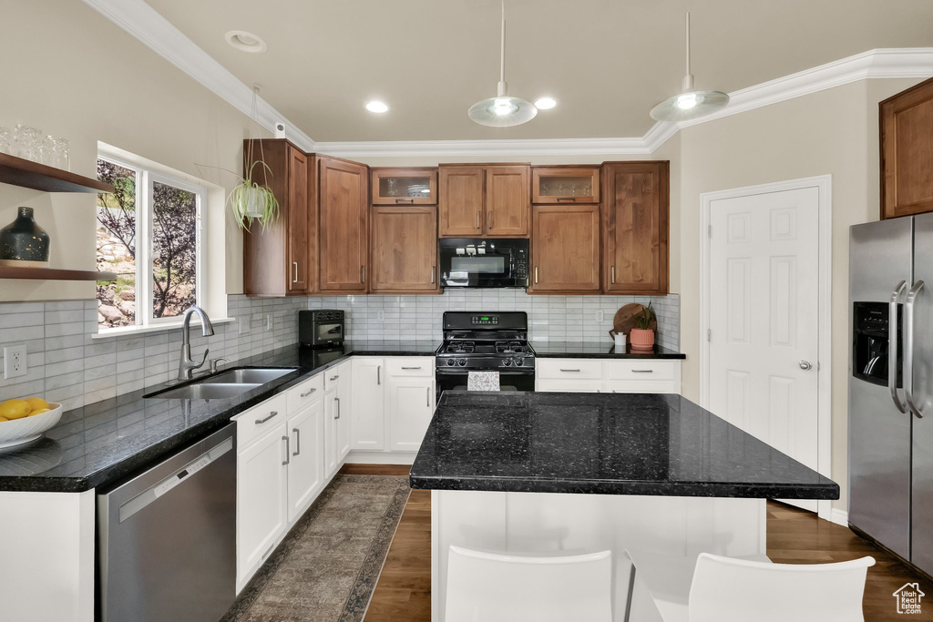 Kitchen featuring a sink, glass insert cabinets, crown molding, dark wood-type flooring, and black appliances