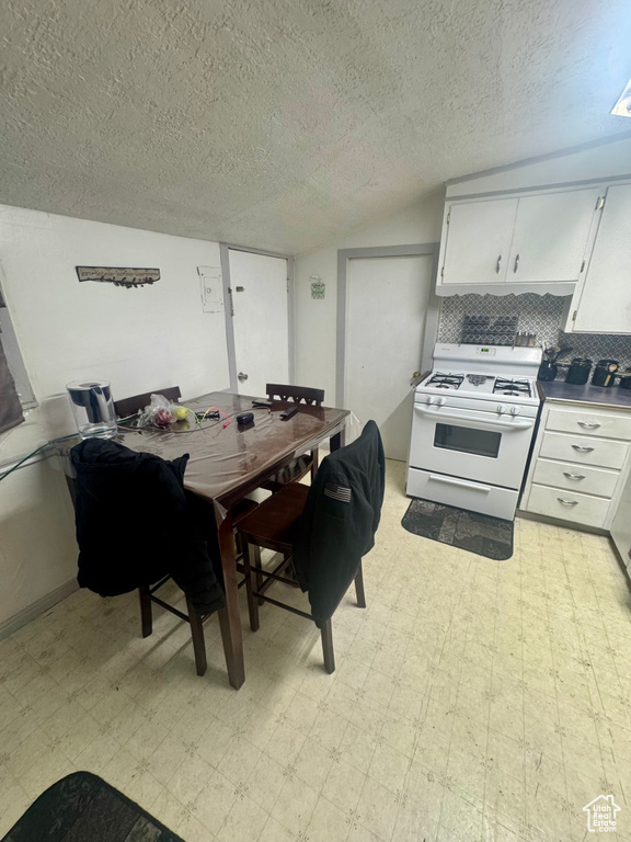 Dining area featuring light floors and a textured ceiling