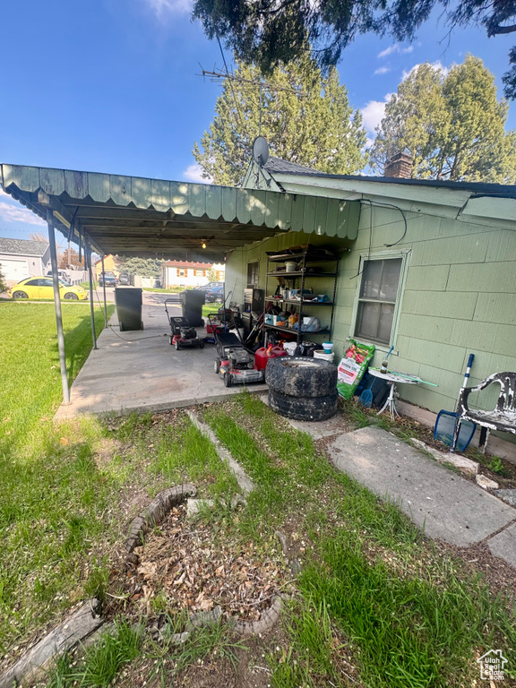 Exterior space with a patio area, a chimney, and a lawn