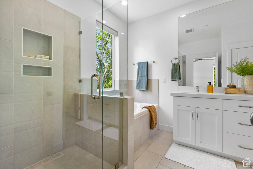 Full bath featuring a shower stall, a garden tub, tile patterned floors, and vanity