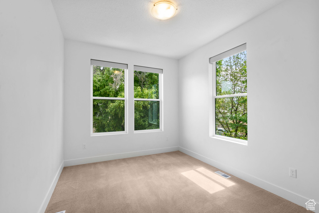 Carpeted empty room featuring baseboards