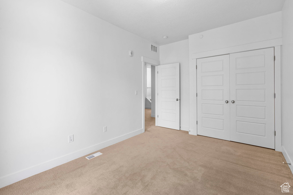 Unfurnished bedroom with carpet floors, baseboards, and a closet