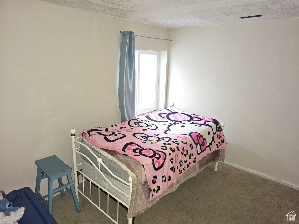 Bedroom featuring a textured ceiling and carpet floors