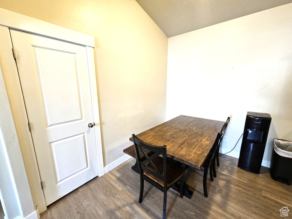 Dining room with wood finished floors, baseboards, and vaulted ceiling