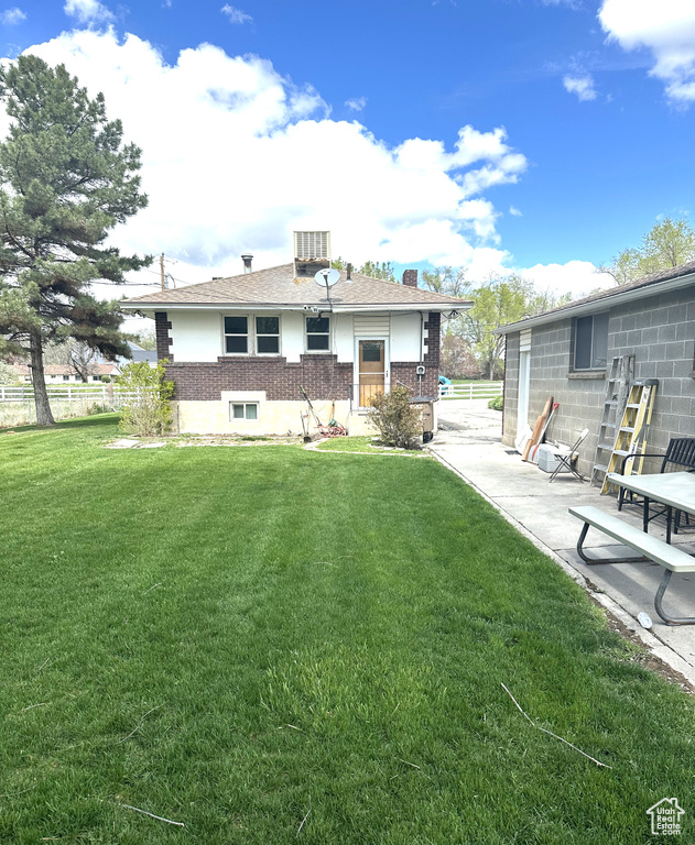 Rear view of house with brick siding and a patio