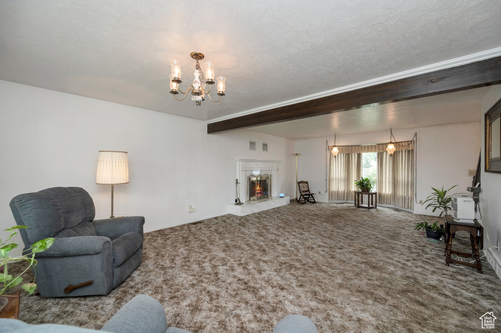 Carpeted living area with a chandelier, baseboards, a textured ceiling, and a fireplace