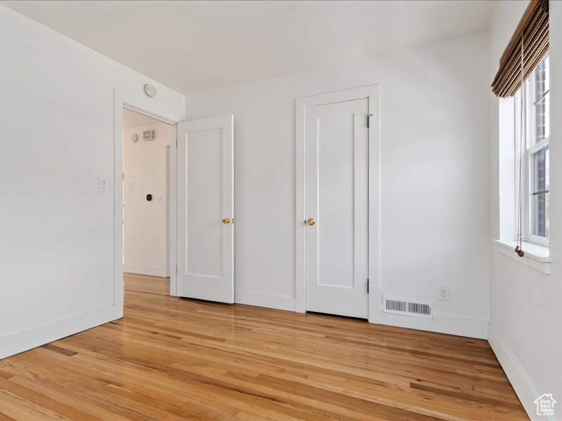 Unfurnished bedroom with baseboards, visible vents, and light wood finished floors