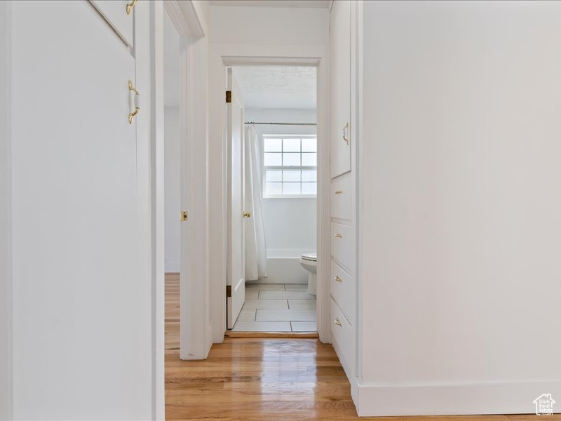 Corridor with baseboards and light wood-style floors