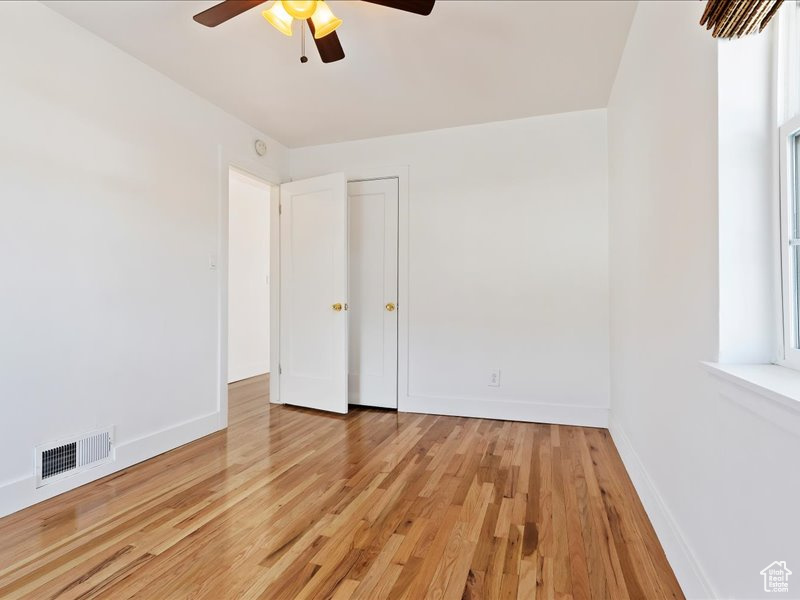 Unfurnished bedroom featuring visible vents, ceiling fan, light wood-style flooring, and baseboards