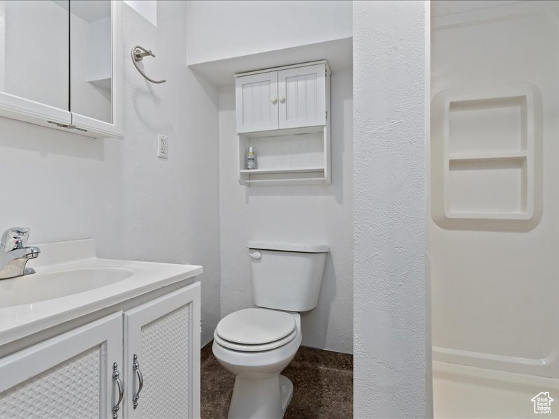 Bathroom with baseboards, toilet, and vanity