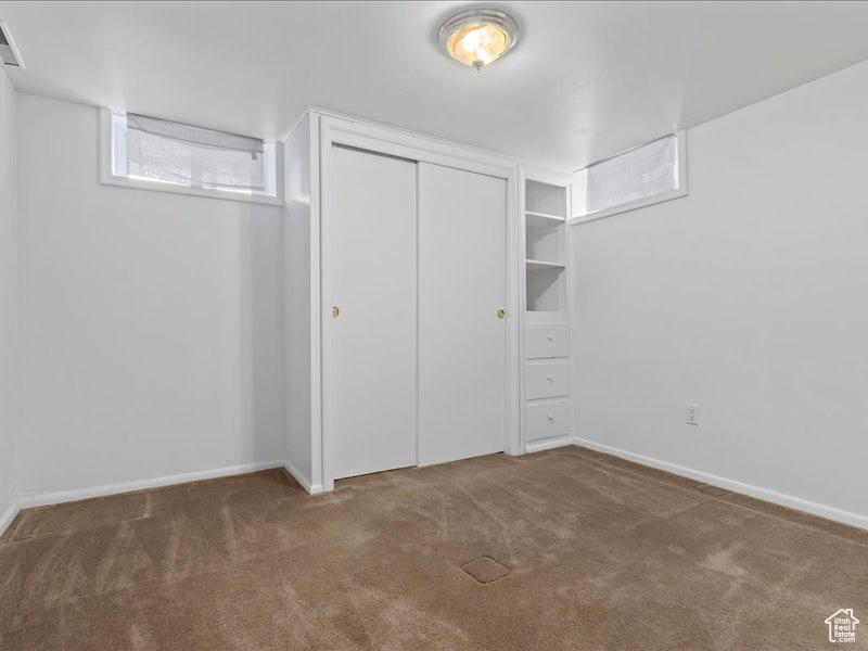 Unfurnished bedroom with baseboards, visible vents, a closet, and carpet