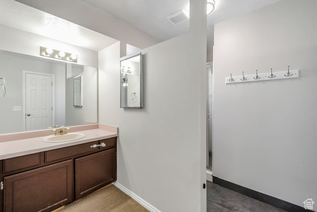 Bathroom featuring vanity, baseboards, and a shower stall