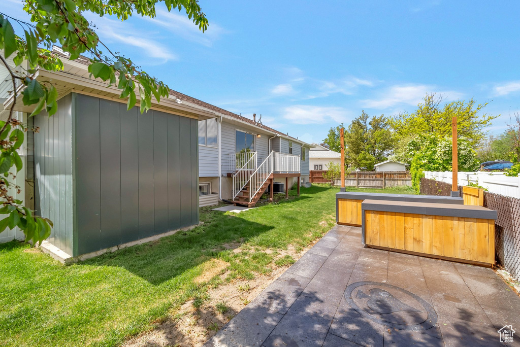 View of yard with a hot tub, a patio, an outdoor structure, and stairway