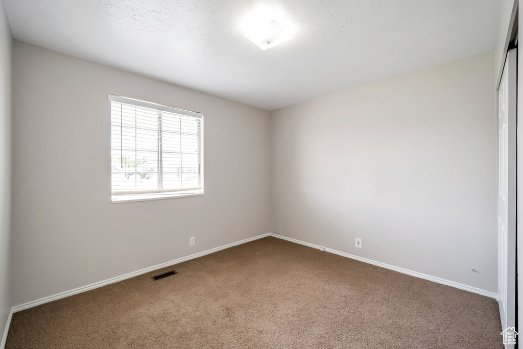 Carpeted spare room with baseboards