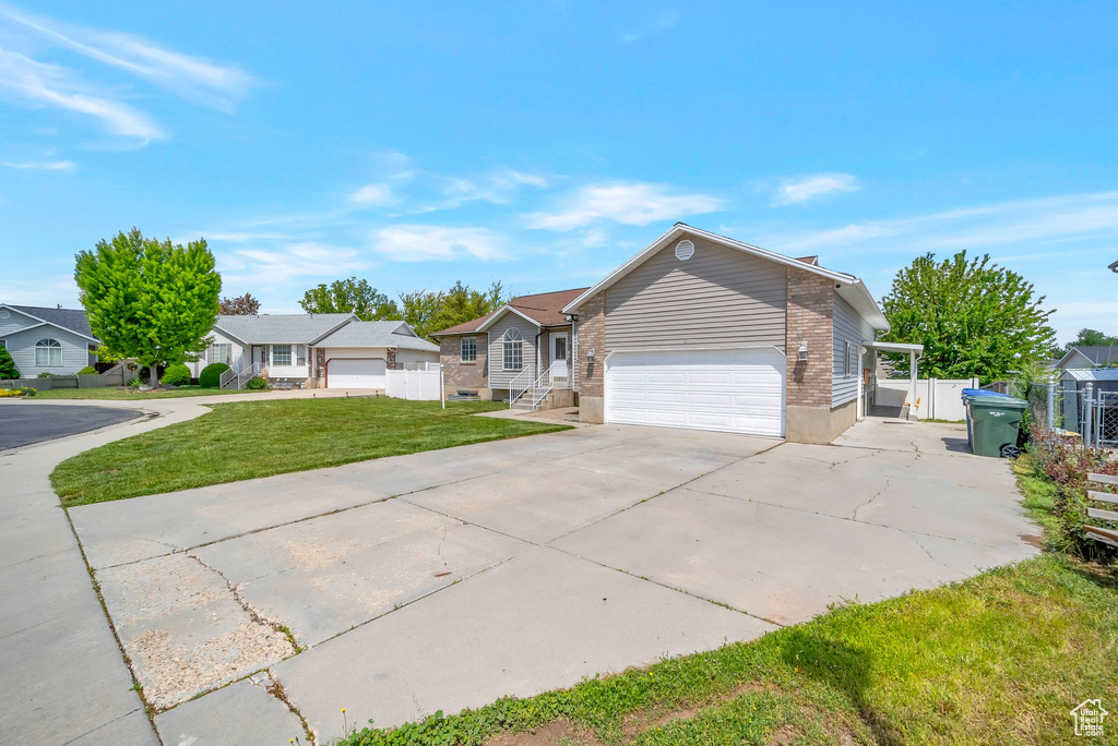 Ranch-style home with driveway, brick siding, a gate, and a residential view