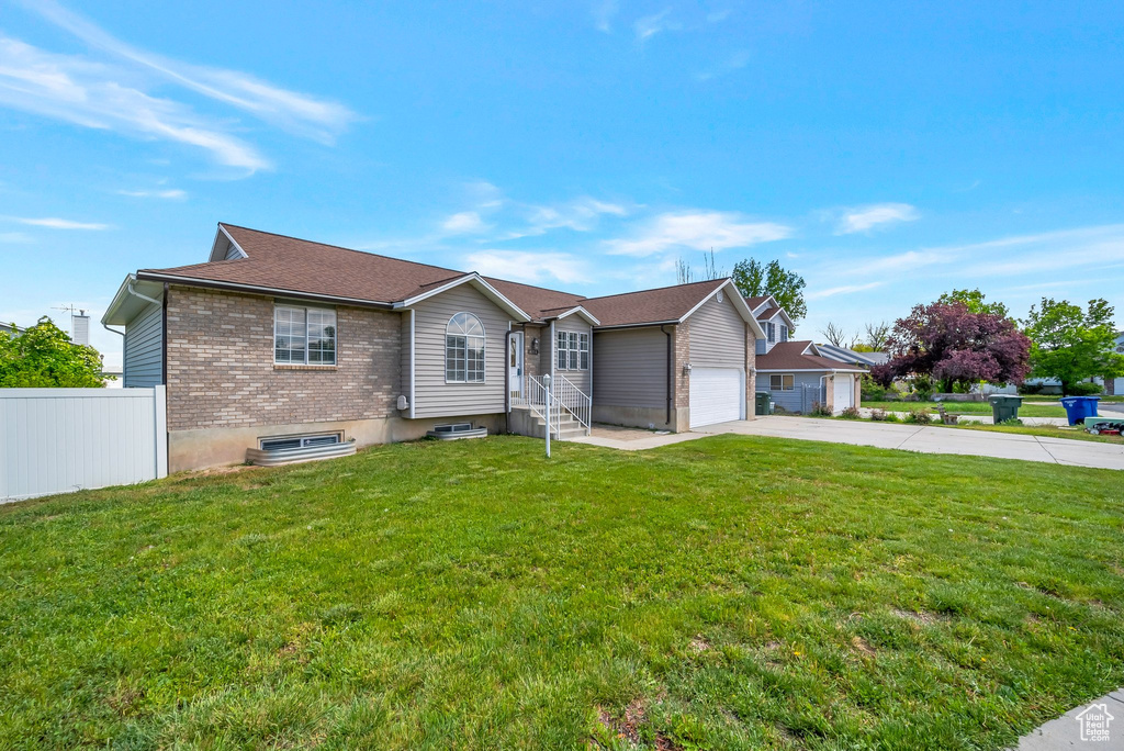 Ranch-style home featuring driveway, an attached garage, and brick siding