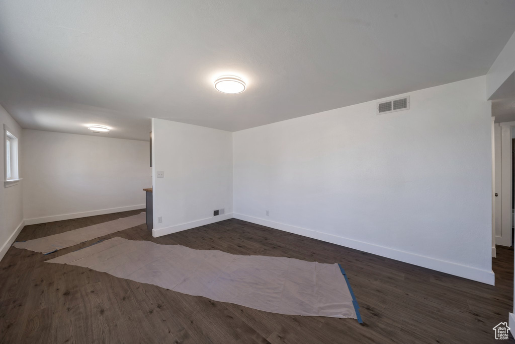 Spare room with baseboards and dark wood finished floors