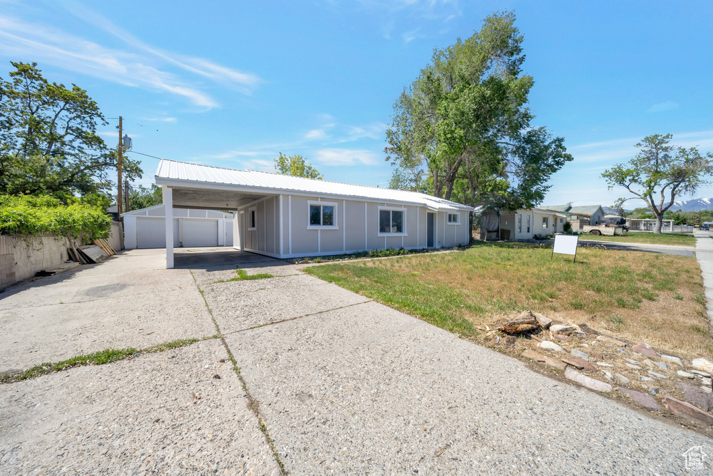 Ranch-style home with board and batten siding, concrete driveway, and an attached carport