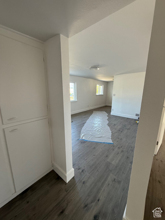 Below grade area with dark wood-style flooring and baseboards