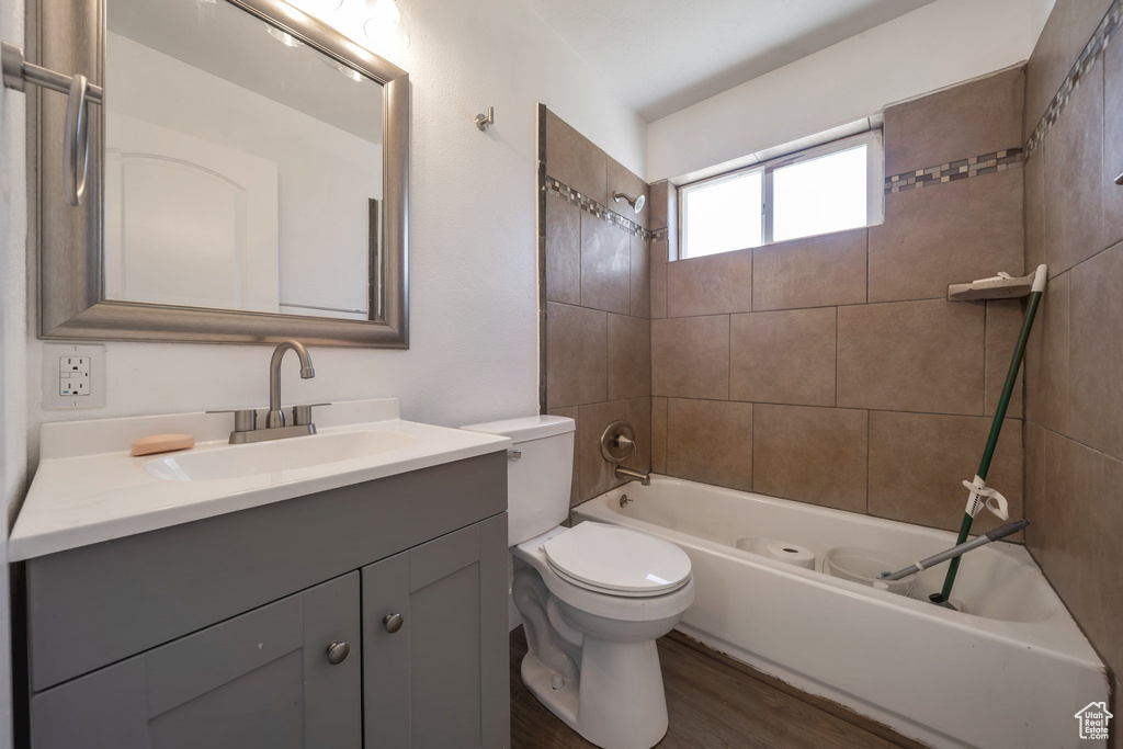 Full bath featuring toilet, vanity, shower / tub combination, and wood finished floors