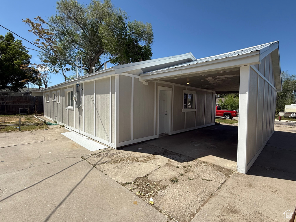 View of side of property featuring an attached carport and driveway