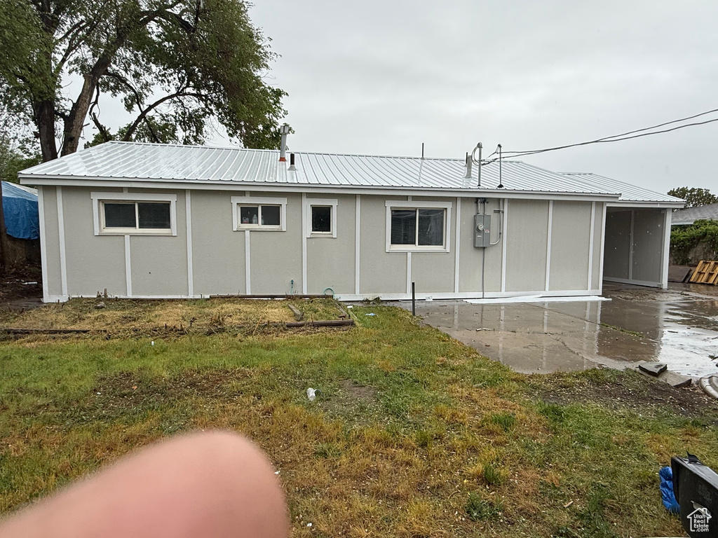 Back of house featuring metal roof and a patio area