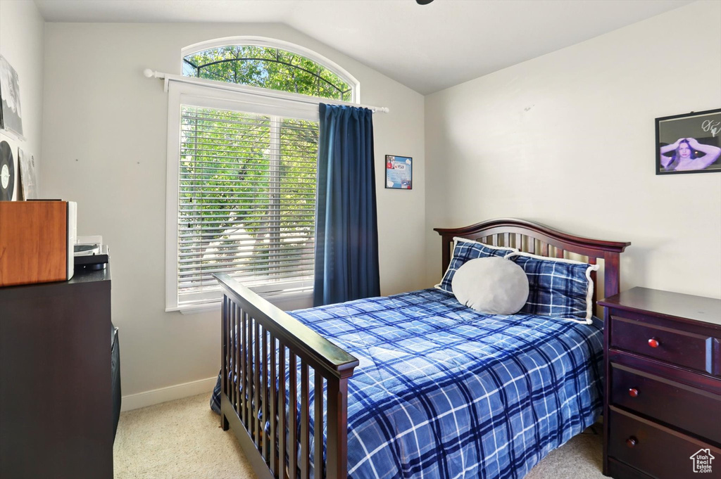 Bedroom featuring lofted ceiling, carpet, and baseboards