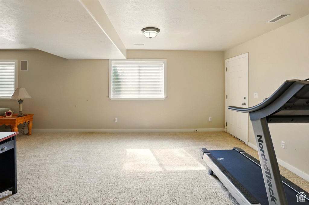 Exercise room featuring baseboards and carpet floors