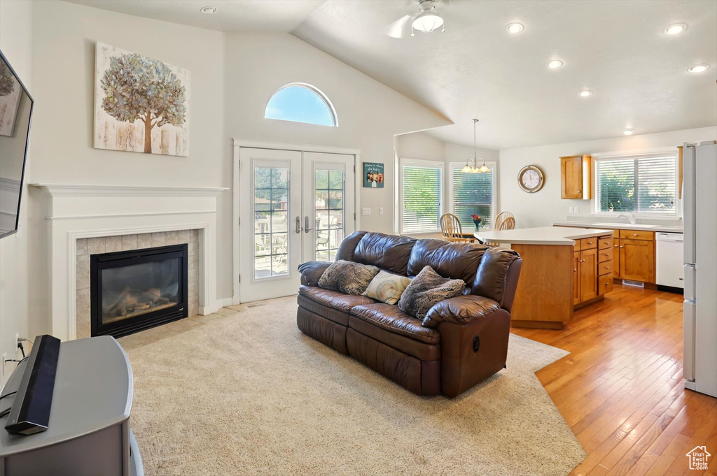 Living room featuring plenty of natural light, lofted ceiling, french doors, recessed lighting, and a ceiling fan