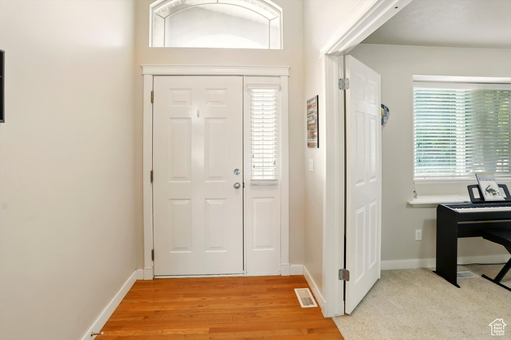 Foyer entrance with baseboards and light wood-type flooring