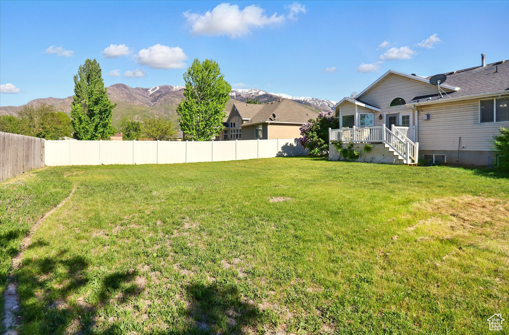 View of yard with a deck with mountain view