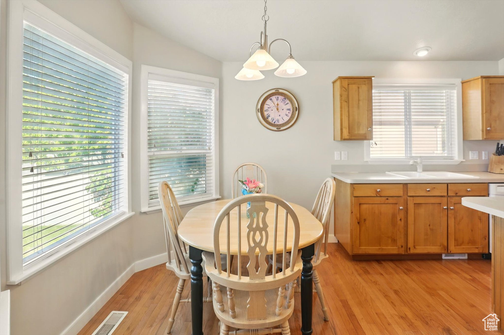 Dining area with light wood-style flooring, baseboards, healthy amount of natural light, and vaulted ceiling