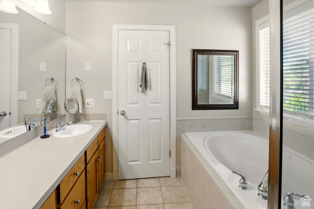 Bathroom with a bath, tile patterned flooring, and vanity