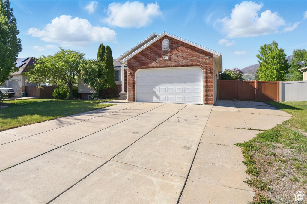 View of front of house with brick siding, a garage, and concrete driveway