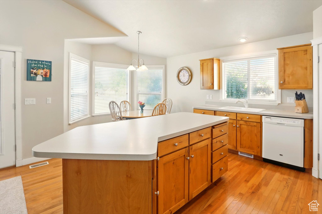 Kitchen featuring dishwasher, a sink, light wood finished floors, light countertops, and lofted ceiling