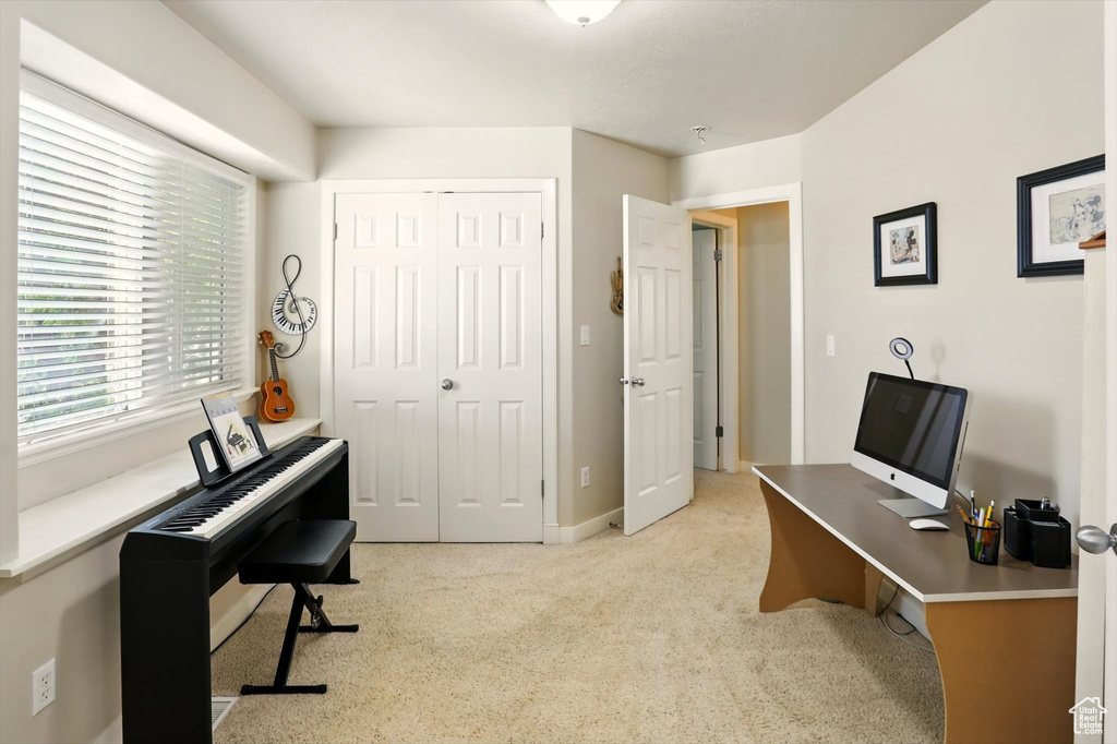 Home office with light colored carpet and baseboards