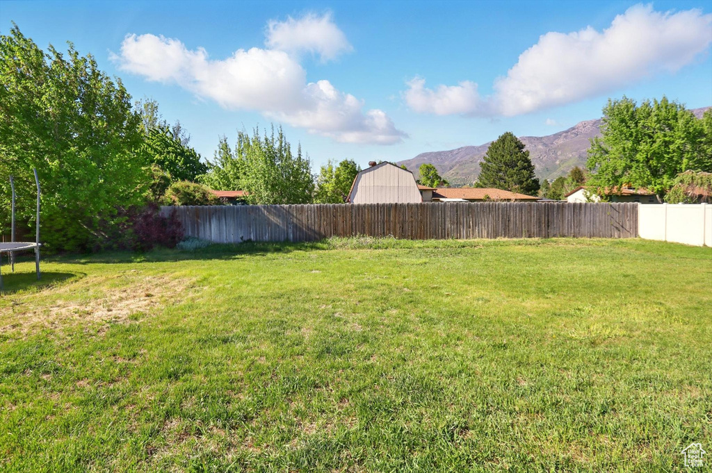 View of yard featuring a trampoline and a mountain view